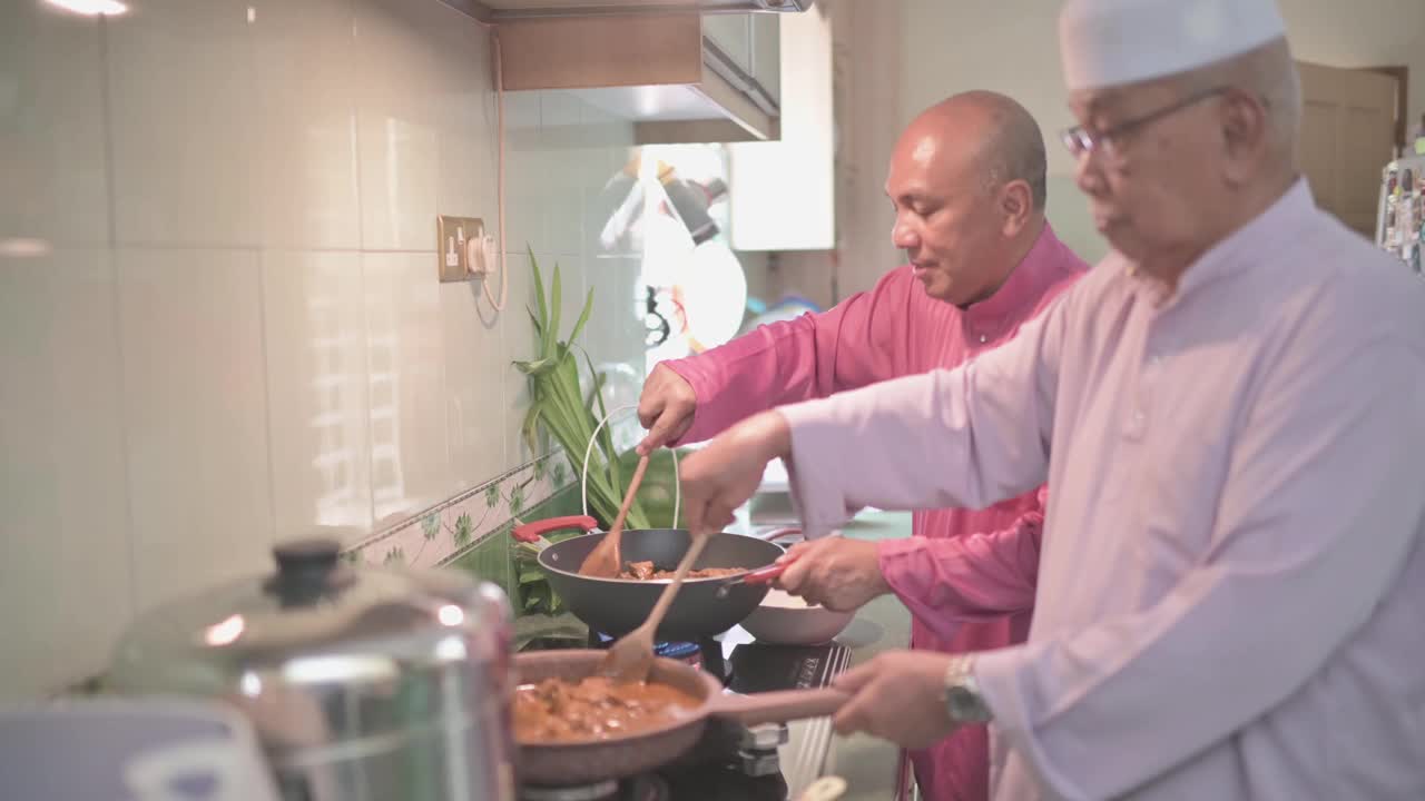 马来家族的祖父和父亲在厨房里并排烹饪传统食物咖喱，准备开斋的家庭团圆饭