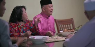 马来亚头发拉亚一家患有唐氏综合症的女儿坐在饭厅等待家人吃团圆饭
