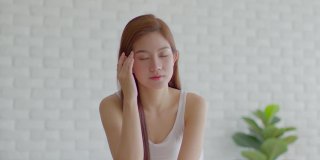 亚洲年轻女性有偏头痛和头痛早上醒来后，保健概念