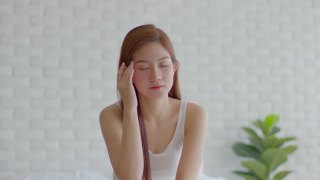 亚洲年轻女性有偏头痛和头痛早上醒来后，保健概念视频素材模板下载