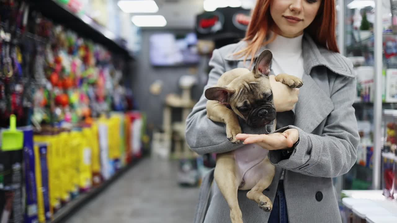 年轻女子在宠物店和她的狗