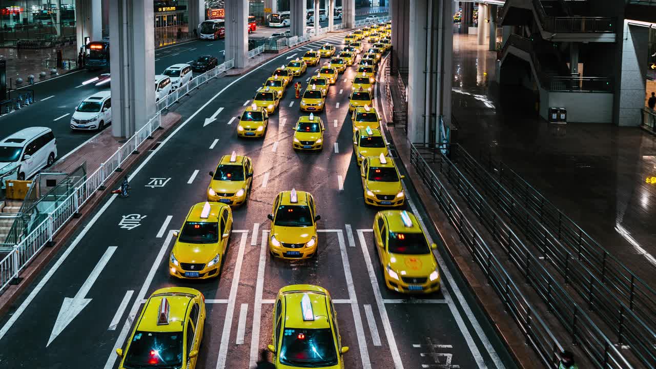 夜间在机场出口排队的黄色出租车