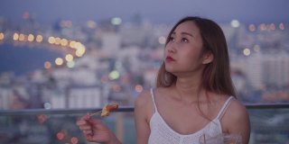 年轻的亚洲女性在晚上吃东西