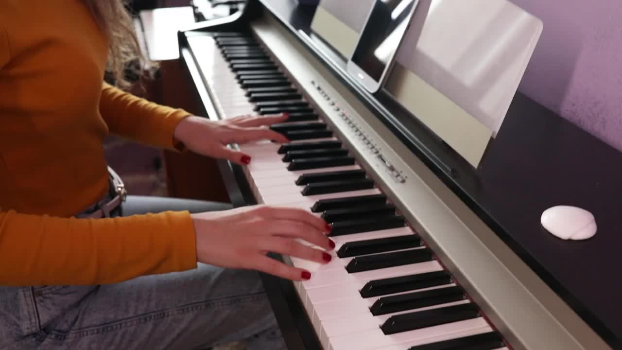 一个女人通过视频学习弹钢琴