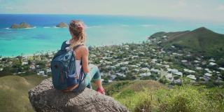 美国夏威夷瓦胡岛山顶上俯瞰大海的年轻女子张开双臂