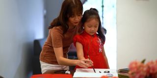 亚洲华人家庭在纸上书写中国书法