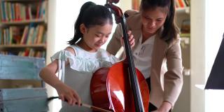 年轻的亚洲女孩学习拉大提琴