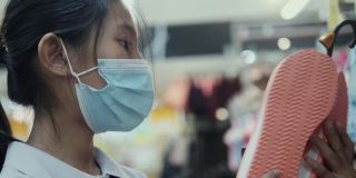 亚洲女学生戴口罩，在超市的零售商店选购商品，新的正常生活理念。