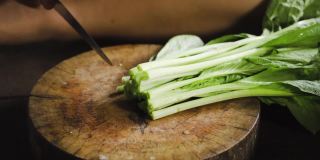 小白菜或中国青菜可以切在木板上。准备吃素。中国菜。亚洲食品。