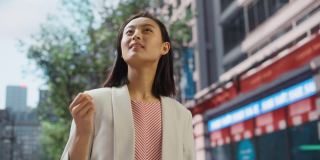美丽的日本女性的肖像穿着漂亮的休闲衣服在街上摆姿势。在大城市生活的成功女性。背景与办公楼和广告牌。