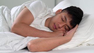 快乐的亚洲年轻人早上睡在舒适的床上。视频素材模板下载