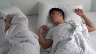 年轻的亚洲男人在床上睡觉时打鼾。视频素材模板下载