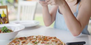 美食博主拍下披萨并在社交媒体上分享。
