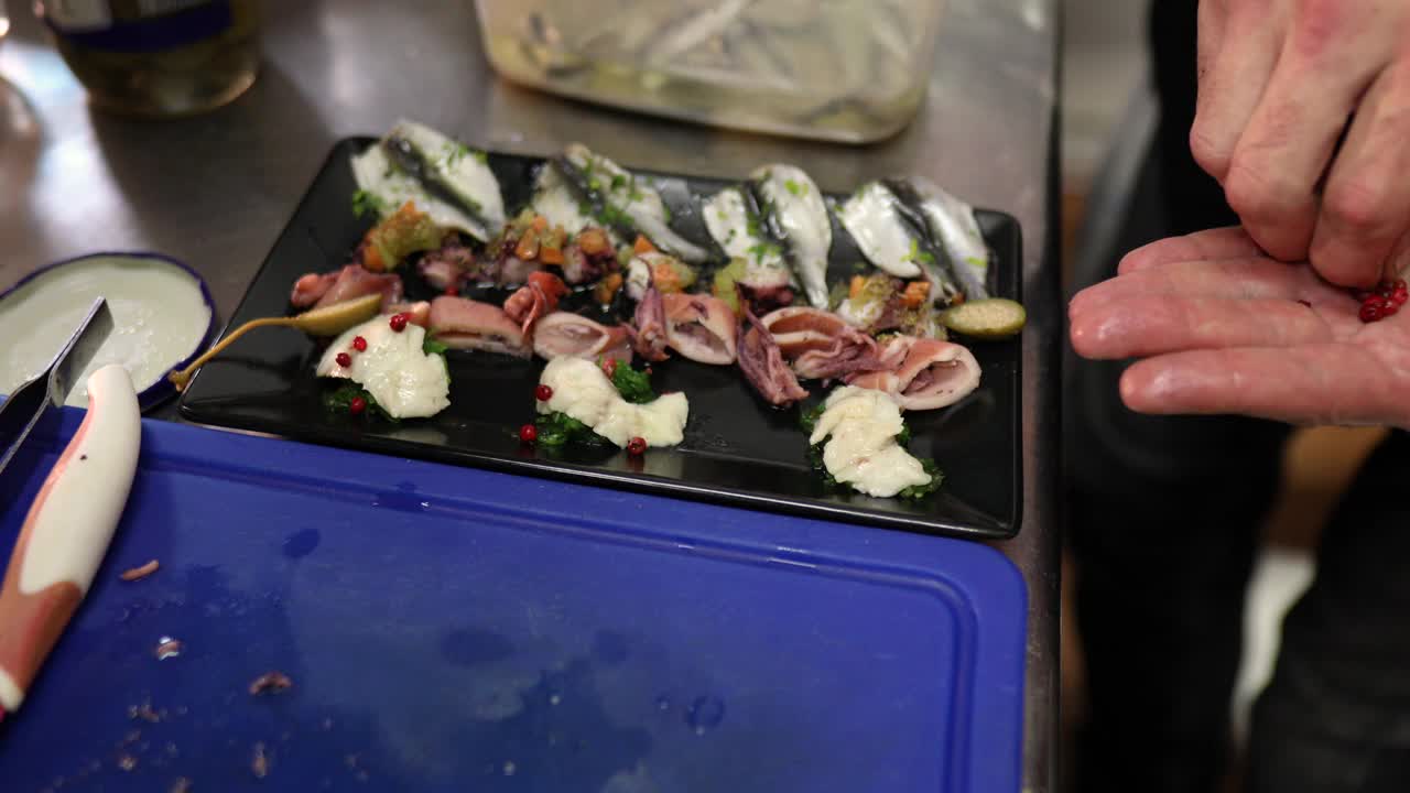 厨师使用异国香料为盘子调味海鲜