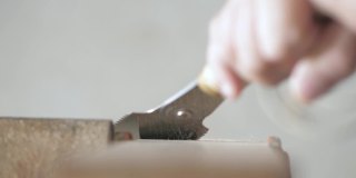 用手锯从橡木板上锯一块木头的木匠。手工木工工具在工作。木工的艺术。手工木工工具的声音