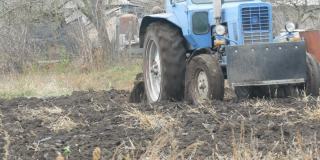 深秋，蓝色的拖拉机在田间犁沟