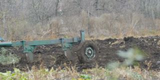 深秋，一辆蓝色的拖拉机在犁地。冬季地面准备