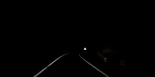 在山区夜间道路上行驶的SUV