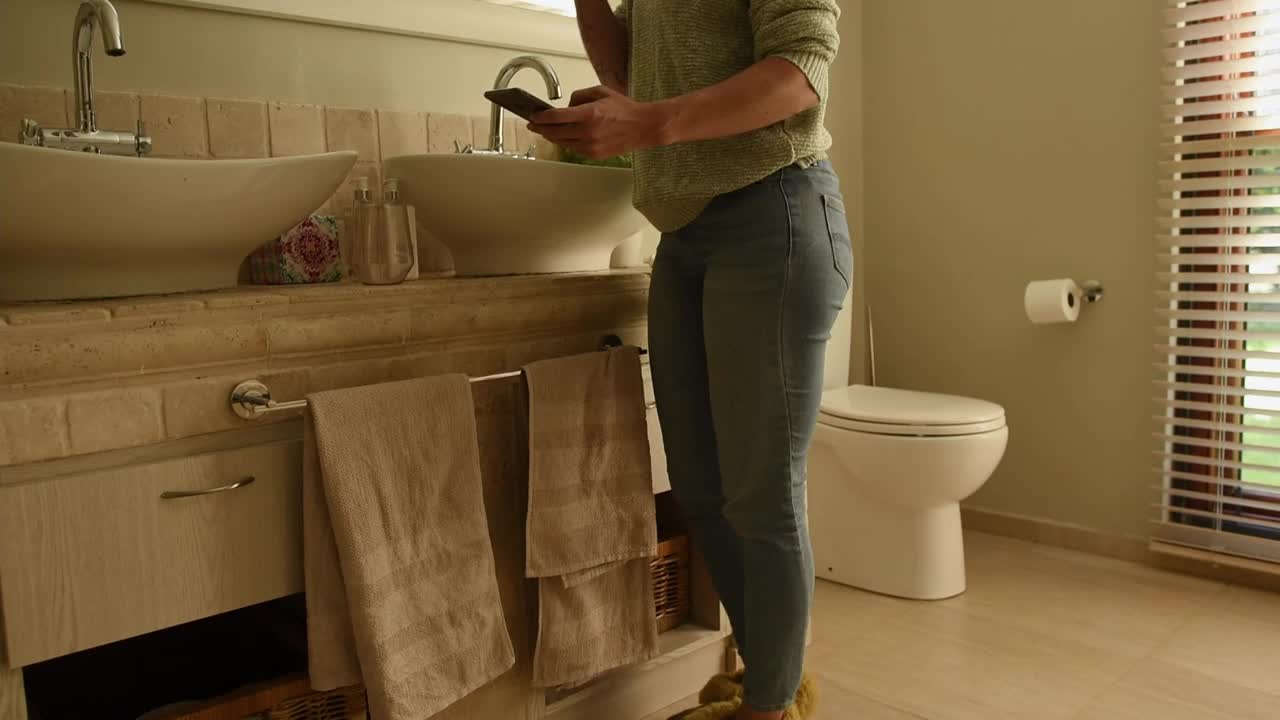 一名女子一边刷牙一边用app打开浴室的百叶窗