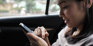 亚洲女性在开车时使用智能手机