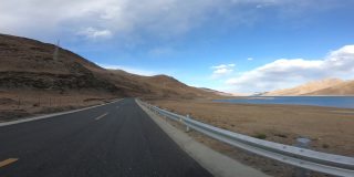 在中国西藏羊卓雍错湖边的小路上行驶
