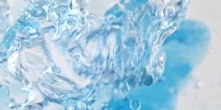 微距拍摄的各种气泡在水上升在轻白色背景。清澈的蓝色水中的氧气泡泡。矿泉水。富含氧气的水。慢动作