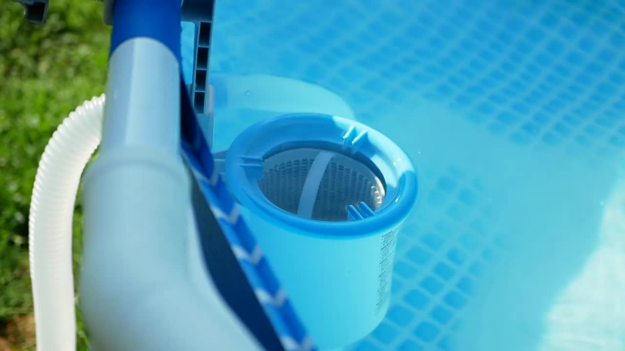 工人的手将白色的药片放入撇水机中。清洗、消毒游泳池内的水。
