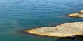 海水清澈碧绿，水面闪闪发光。美丽的夏天海景。令人惊叹的深海透明水域。闪着蓝绿色的地中海。放松、游泳、禅、涅槃、夏日清新天堂