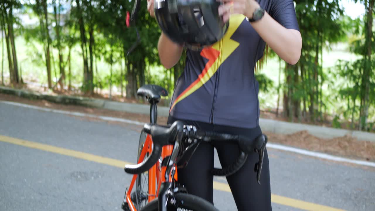 女性自行车运动员在锻炼前戴上头盔