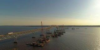 波托马克河重建鸟瞰图，靠近哈里·尼斯州长纪念馆/参议员托马斯·“麦克”·米德尔顿桥，连接弗吉尼亚州和马里兰州，水上有多艘浮吊船和建筑工地。