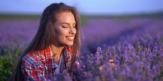 女孩的手抚摸着，嗅着田野里紫色的薰衣草花。