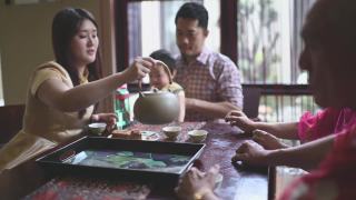 中国女儿在多代同堂期间喝茶，享用传统的中秋节月饼和下午茶聚会期间在家喝茶视频素材模板下载