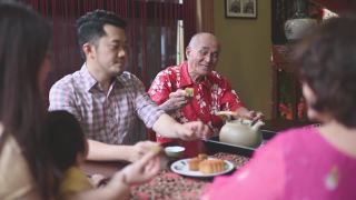 中国儿子在多代同堂期间喝茶，享用传统的中秋节月饼和下午茶聚会期间在家喝茶视频素材模板下载