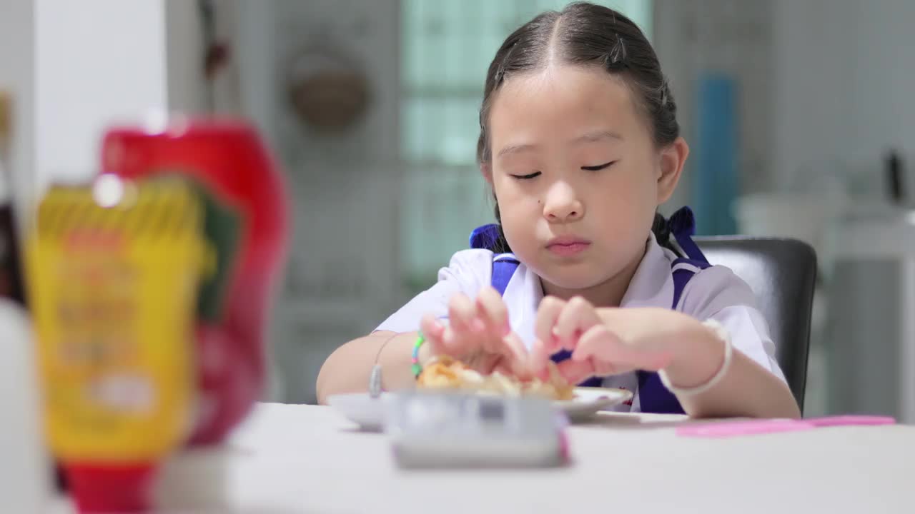 女孩在上学前穿着校服吃早餐