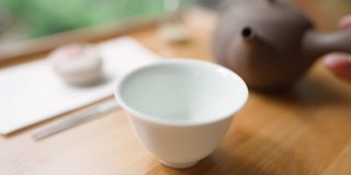 女用手将日本绿茶从罐中倒出。