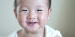 特写快乐微笑亚洲可爱的宝贝女孩，宝宝积极的情绪，快乐的时间概念