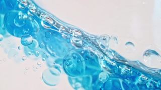 蓝色波浪水与泡沫在白色的背景。清澈的蓝色水中的氧气泡泡。矿泉水。富含氧气的水。缓慢的运动。微距镜头视频素材模板下载