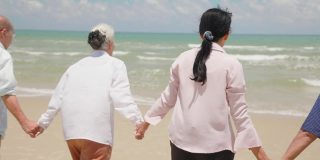 亚洲老年人在度假中跑到海边，在海边享受。快乐的退休年龄，在热带海滩享受假期。旅行的夏天和年轻的回忆概念