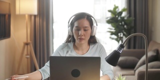 亚洲女人正在用笔记本电脑进行视频通话