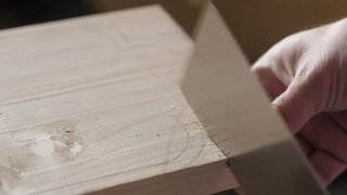 木匠用手锯从一块松木板上锯下一块木头。手工木工工具在工作。木工艺术视频素材模板下载