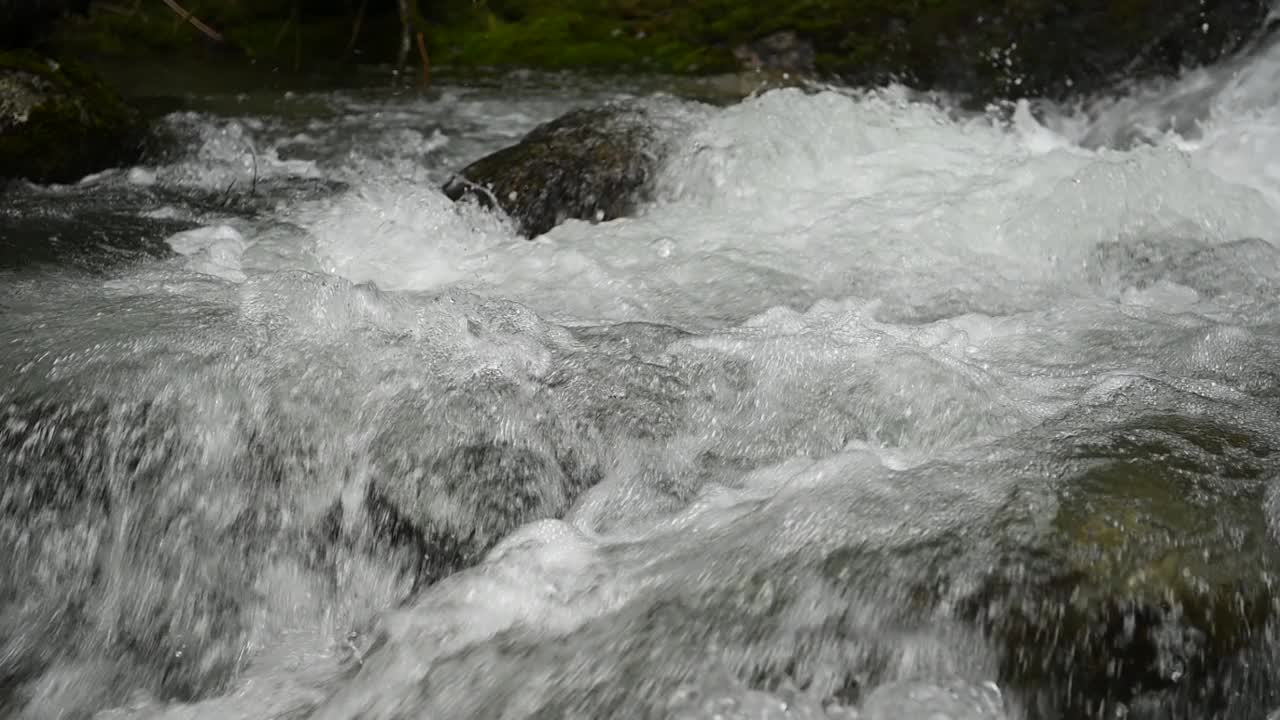 慢条斯理的山涧清澈，小溪流过岩石。河面近石随流水，清澈见底的流水在山间流淌