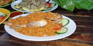 美味的印尼海鲜蟹菜，用香料和调味汁包在芭蕉叶盘里，与印尼餐厅的其他背景菜一起烹制