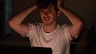 绝望的人双手抱头坐在笔记本电脑前，对无法解决的问题感到压力。视频素材模板下载