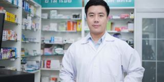 医生在医院的药房工作。亚洲药剂师在药店摆姿势和展示药剂学背景。医疗、商业和生活方式的概念。