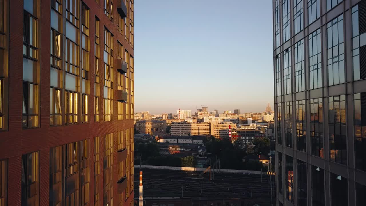 镜头在夕阳照耀下的两座高层建筑之间移动。办公大楼