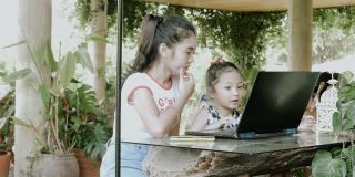 可爱的泰国女孩给她的妹妹看什么卡通频道，她喜欢看网上股票视频