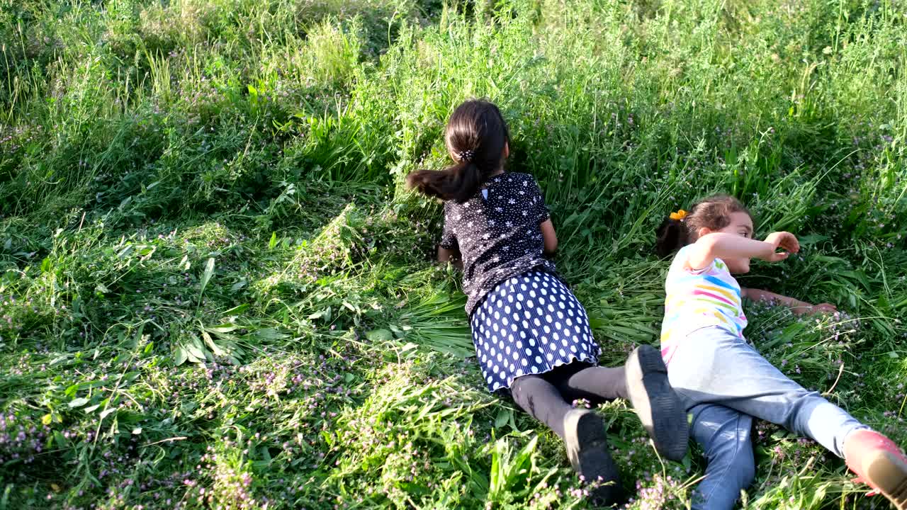 小女孩们在田野的草地上打滚