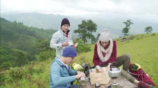 一群亚洲朋友一起在山上露营，坐在户外椅子上喝着热咖啡视频素材模板下载