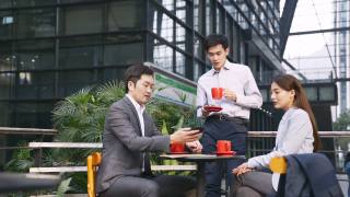 三位亚洲商务人士在户外咖啡馆会面视频素材模板下载