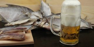 啤酒头安置在一个玻璃马克杯上，背景是鳕鱼